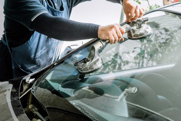 mechanics-man-changing-broken-windshield-automobile-windshield-windscreen-replacement-white-car-auto-repair-shop (Copy)